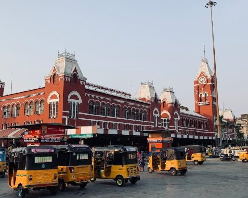 a group of yellow buses parked in front of a building