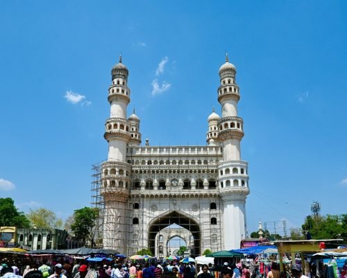 a group of people standing in front of a tall white building